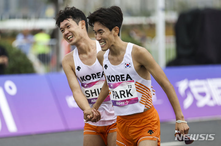 [항저우=뉴시스] 정병혁 기자 = 5일 중국 항저우 첸탕강 스마트 뉴월드 일대에서 열린 2022 항저우 아시안게임 육상 남자 마라톤에서 심종섭과 박민호가 결승선을 통과한 뒤 서로를 격려하고 있다. 결과는 심종섭 7위, 박민호 11위. 2023.10.05. jhope@newsis.com