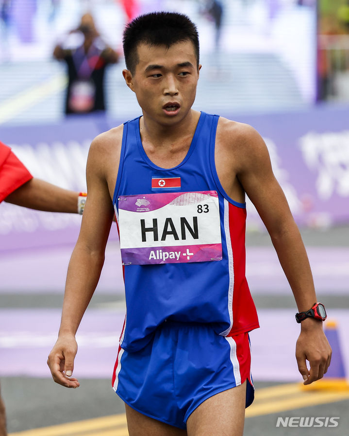 [항저우=뉴시스] 정병혁 기자 = 5일 중국 항저우 첸탕강 스마트 뉴월드 일대에서 열린 2022 항저우 아시안게임 육상 남자 마라톤에서 은메달을 차지한 북한 한일룡이 결승선을 통과한 뒤 자국 응원단을 찾고 있다. 2023.10.05. jhope@newsis.com