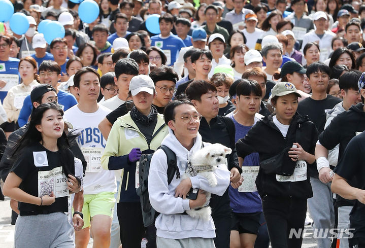 [서울=뉴시스] 황준선 기자 = 6일 오전 서울 구로구 마리오타워에서 열린 제18회 G-밸리 스마트 마라톤 대회에서 한 참가자가 반려견과 함께 달리고 있다. 2023.10.06. hwang@newsis.com