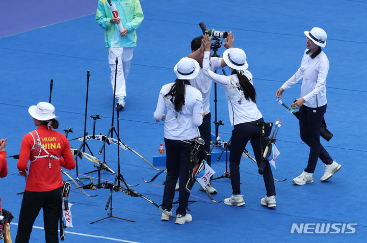[항저우=뉴시스] 고승민 기자 = 6일 중국 항저우 푸양 인후 스포츠센터에서 열린 2022 항저우 아시안게임 여자 양궁 리커브 단체 결승 한국 대 중국 경기, 중국을 세트스코어 5-3으로 꺾고 금메달을 차지한 한국 안산, 최미선, 임시현이 양창훈 감독과 기뻐하고 있다. 2023.10.06. kkssmm99@newsis.com