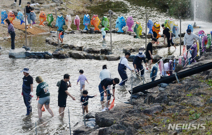 [완주=뉴시스] 김얼 기자 = 제11회 완주와일드&로컬푸드축제가 개막한 6일 전북 완주군 고산자연휴양림 일원에서 시민들이 물고기 잡기를 하며 축제를 즐기고 있다. 2023.10.06. pmkeul@newsis.com