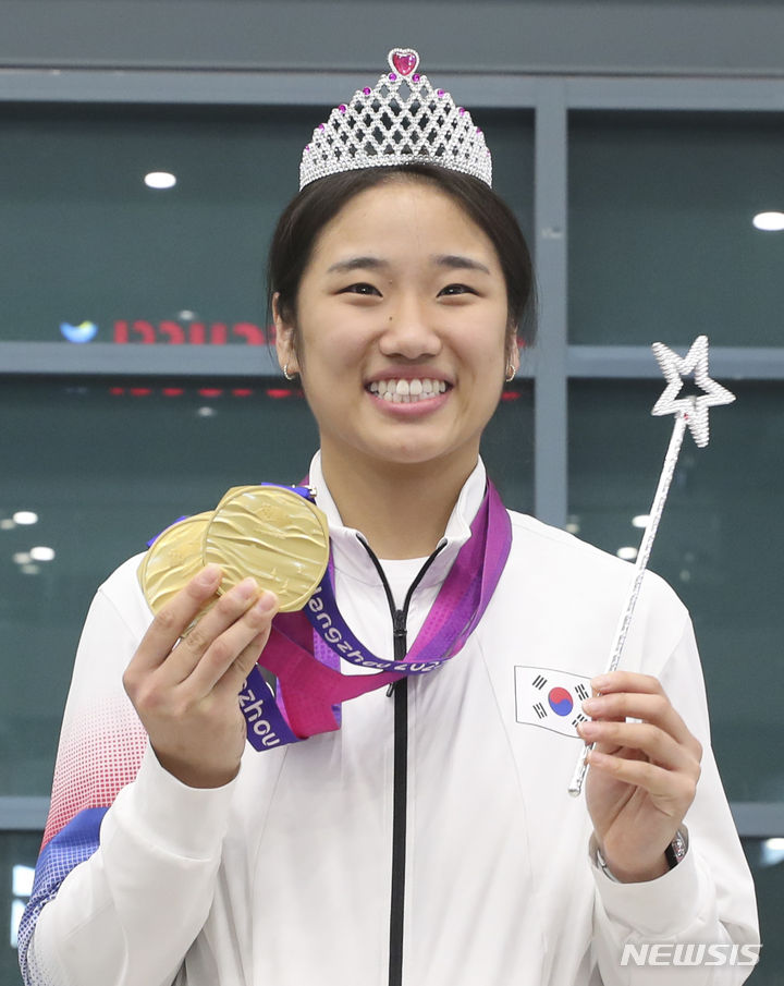 [인천공항=뉴시스] 김근수 기자 = 2022 항저우 아시안게임 대한민국 배드민턴 대표팀 안세영 선수가 8일 인천국제공항 제1여객터미널 입국장 앞에서 성지현 국가대표팀 코치에게 왕관을 받고 기념촬영을 하고 있다. 2023.10.08. ks@newsis.com