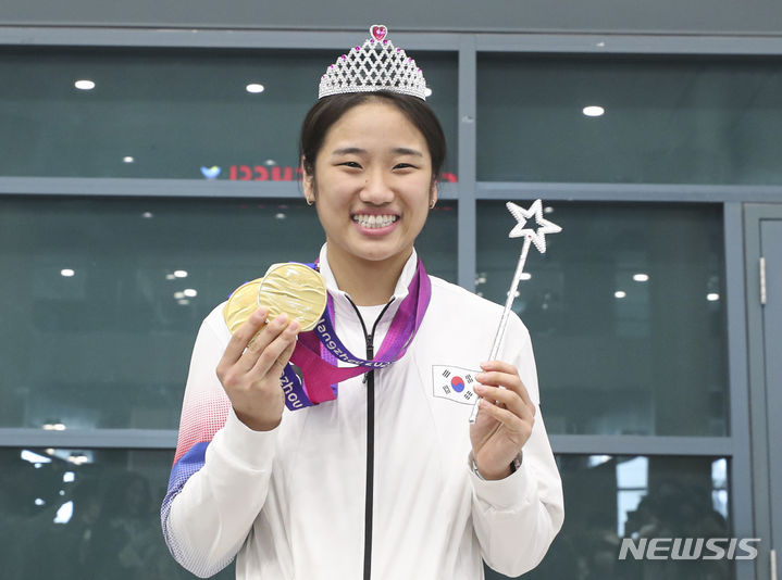 [인천공항=뉴시스] 김근수 기자 = 2022 항저우 아시안게임 대한민국 배드민턴 대표팀 안세영 선수가 8일 인천국제공항 제1여객터미널 입국장 앞에서 성지현 국가대표팀 코치에게 왕관을 받고 기념촬영을 하고 있다. 2023.10.08. ks@newsis.com