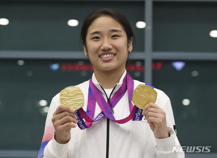 [인천공항=뉴시스] 김근수 기자 = 2022 항저우 아시안게임 대한민국 배드민턴 안세영 선수가 8일 인천국제공항 제1여객터미널 입국장 앞에서 열린 환영행사에서 금메달을 들어보이고 있다. 2023.10.08. ks@newsis.com