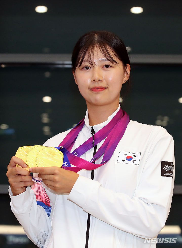 [인천공항=뉴시스] 김근수 기자 = 제19회 항저우 아시안게임 양궁 3관왕을 기록한 임시현이 8일 오후 인천국제공항을 통해 귀국해 메달을 들고 기념촬영하고 있다. 양궁 여자 리커브 임시현은 여자 단체전, 혼성, 개인전을 모두 휩쓸며 금메달 3개를 따냈다. 2023.10.08. ks@newsis.com