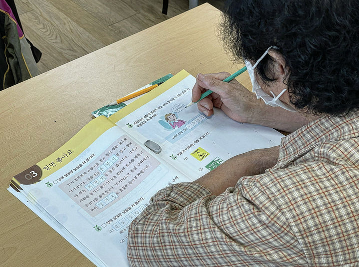 [대구=뉴시스] 정재익 기자 = 한글날을 사흘 앞둔 6일 오후 대구시 서구 날뫼학당 수업에 참여한 한 노인이 교재에 글을 쓰고 있다. 2023.10.09. jjikk@newsis.com *재판매 및 DB 금지