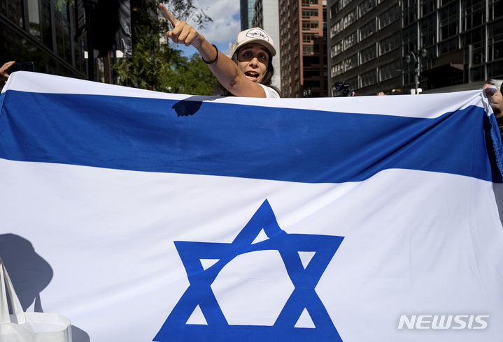 [뉴욕=AP/뉴시스] 이스라엘과 팔레스타인 무장정파 하마스 간 무력 충돌이 확전 양상을 보이는 가운데 미국 여론은 분쟁에 직접 휘말리는 상황을 경계하고 있는 것으로 나타났다. 사진은 9일(현지시간) 미국 뉴욕의 이스라엘 영사관 앞에서 이스라엘을 지지하는 사람이 이스라엘 국기를 들고 팔레스타인 지지자들을 향해 소리치는 모습. 이날 이스라엘 영사관 부근에는 이스라엘과 팔레스타인을 지지하는 사람들이 모여 시위를 벌였다. 2023.10.23.