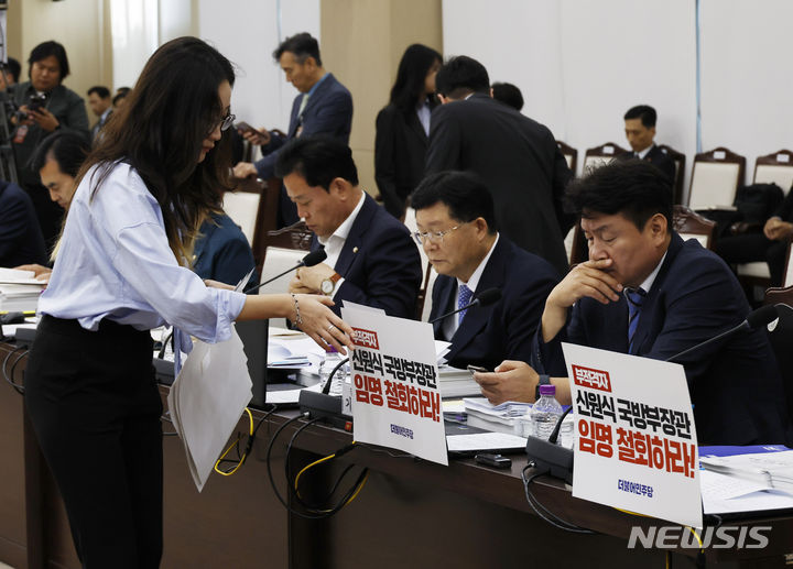 [서울=뉴시스] 국회사진기자단 = 10일 오후 서울 용산구 국방부에서 열린 국회 국방위원회의 국방부에 대한 국정감사에서 더불어민주당 관계자가 의원 노트북에 붙은 피켓을 떼어 내고 있다. 2023.10.10. photo@newsis.com