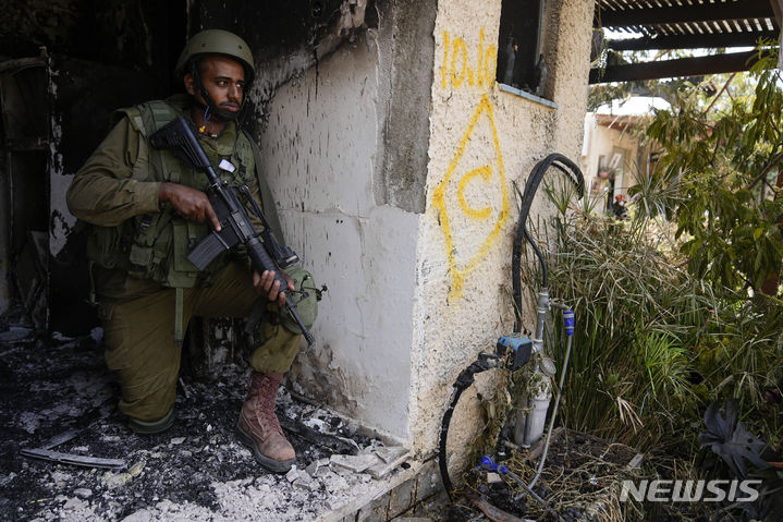 [키부츠=AP/뉴시스] 이스라엘 방위군(IDF) 대변인이 시가전을 개시하면 민간인 희생은 불가피하다고 말했다. 사진은 지난 10일(현지시각) 이스라엘 키부츠에서 한 이스라엘 군인이 건물에 몸을 엄폐한 뒤 전투 준비를 한 모습. 2023.10.22.