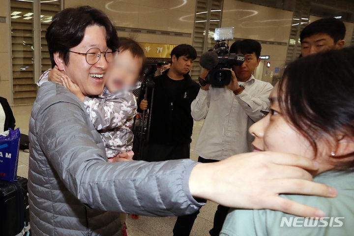 [인천공항=뉴시스] 조성우 기자 = 팔레스타인 무장 정파 하마스와  이스라엘 간 무력 충돌이 진행 중인 가운데 이스라엘 현지에 머물던 성지순례객 등 한국인 단기 체류자들이 11일 오전 인천국제공항 제2여객터미널을 통해 귀국했다. 한 시민이 귀국하는 아이와 부인을 반갑게 맞이하고 있다. 2023.10.11. xconfind@newsis.com