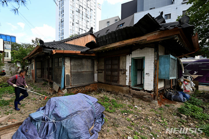 [광주=뉴시스] 이영주 기자 = 국가보훈부가 광주시를 향해 정율성 기념 사업 중단을 권고한 11일 오후 광주 동구 불로동 정율성 생가 복원 현장에서 한 인부가 풀을 베고 있다. 2023.10.11. leeyj2578@newsis.com