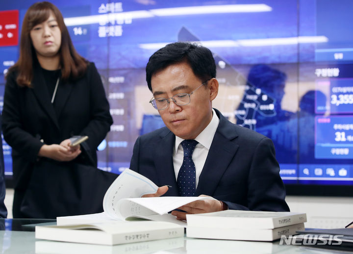 [서울=뉴시스] 김진아 기자 = 진교훈 강서구청장이 12일 오전 서울 강서구청 구청장실에서 사무 인계·인수서에 서명을 하고 있다. 2023.10.12. bluesoda@newsis.com