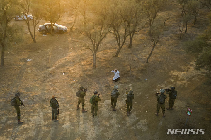 [가자지구=AP/뉴시스] 12일(현지시각) 가자지구 인근에서 이스라엘 군인들이 음악 축제 현장에서 칼을 들고 달려든 팔레스타인 남성을 포위하고 있다. 지난 7일 이스라엘 남부 레임 키부츠 음악 축제장에 하마스가 기습 공격해 최소 260명이 숨진 바 있다. 2023.10.13.