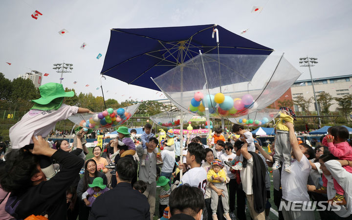 [서울=뉴시스] 김선웅 기자 = 13일 서울 송파여성축구장에서 열린 송파구 주최·송파구가정어린이집연합회 주관 '아기새들의 놀이한마당' 가을운동회에서 참여 어린이들과 학부모, 보육 교직원들이 공던지기 경기를 하고 있다. 2023.10.13. mangusta@newsis.com