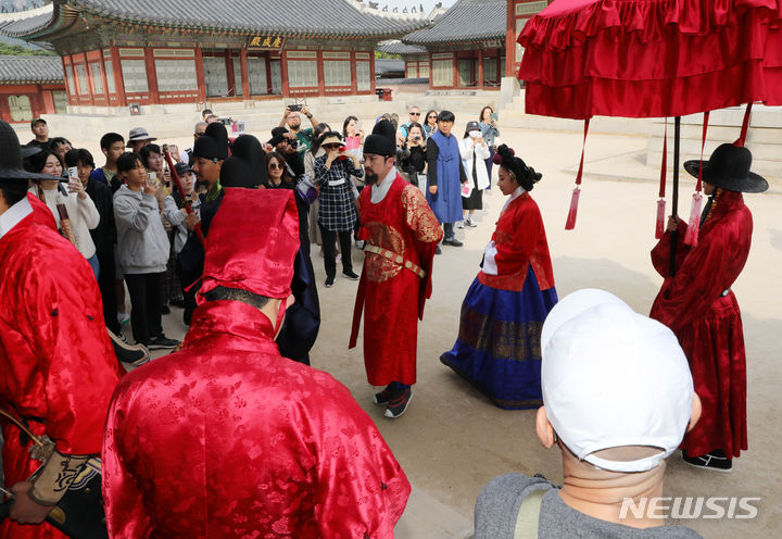 [서울=뉴시스] 배훈식 기자 = 13일 오전 서울 종로구 경복궁을 찾은 관광객들이 궁궐의 일상 모습을 체험할 수 있는 '왕가의 산책' 재연 행사를 관람하고 있다. 2023.10.13. dahora83@newsis.com