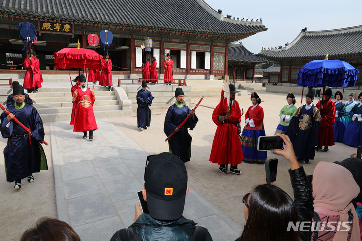 [서울=뉴시스] 배훈식 기자 = 13일 오전 서울 종로구 경복궁을 찾은 관광객들이 궁궐의 일상 모습을 체험할 수 있는 '왕가의 산책' 재연 행사를 관람하고 있다. 2023.10.13. dahora83@newsis.com