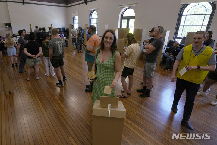 [시드니(호주)=AP/뉴시스]원주민들의 목소리를 의회에 반영시키는 메커니즘을 헌법에 포함시킬 것인지를 묻는 국민투표가 치러진 14일 호주 시드니의 한 투표소에서 여성 한 명이 투표함에 자신의 투표용지를 넣고 있다. 호주 유권자들은 이날 국민투표에서 원주민들이 그들의 삶에 영향을 미치는 정책에 대해 의회에 조언할 수 있는 메커니즘을 헌법에 포함시키는 것에 반대했다. 20123.10.14.