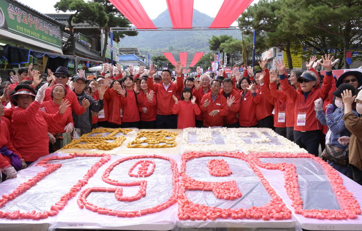 [순창=뉴시스] 김종효 기자 = 14일 ‘제18회 순창장류축제’ 2일차, 새롭게 선보인 축제 주요 프로그램 ‘300m 가래떡 꼬기’가 열띤 성원 속에 펼쳐졌다. 행사 후 나눔떡으로 잘려 모양을 낸 가래떡판 주위로 참여자들이 기념사진을 찍고 있다. (사진 = 순창군 제공) 2023.10.14. photo@newsis.com  *재판매 및 DB 금지