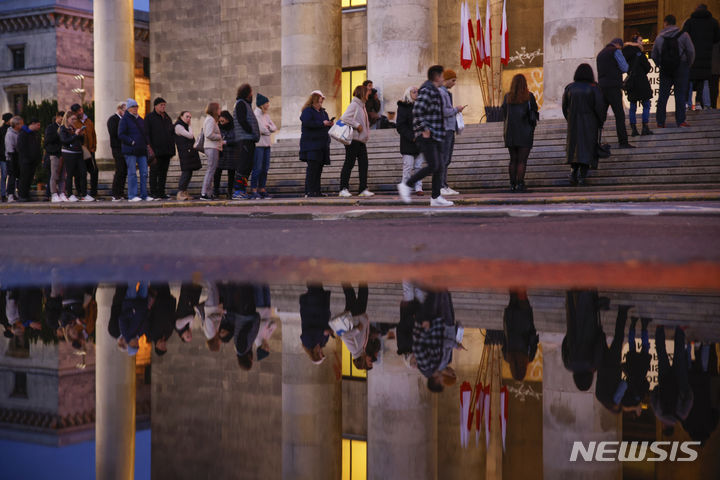 [바르샤바=AP/뉴시스] 폴란드 총선이 치러진 15일(현지시간) 수도 바르샤바 시내의 한 투표소 앞에서 사람들이 길게 줄을 지어 차례를 기다리고 있다. 2023.10.17.