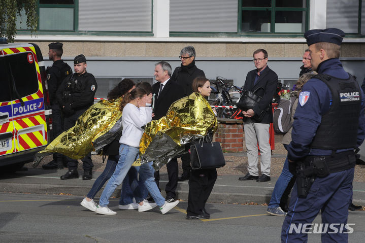 [아라스=AP/뉴시스] 프랑스 수도 파리에서 경찰이 열차 안에서 자폭 위협을 한 이슬람교도 복식을 한 용의자에게 8발을 발포해 이를 제압했다. 총기 사용을 두고 적절성 논란이 빚어지자 프랑스 검찰은 발포가 적절했는지 규명하겠다고 밝혔다. 사진은 지난달 16일(현지시각) 프랑스 동북부 아라스의 강베타 고등학교에 폭발물 협박 신고가 접수된 뒤 경찰관이 학생을 호위하는 모습. 2023.11.01.