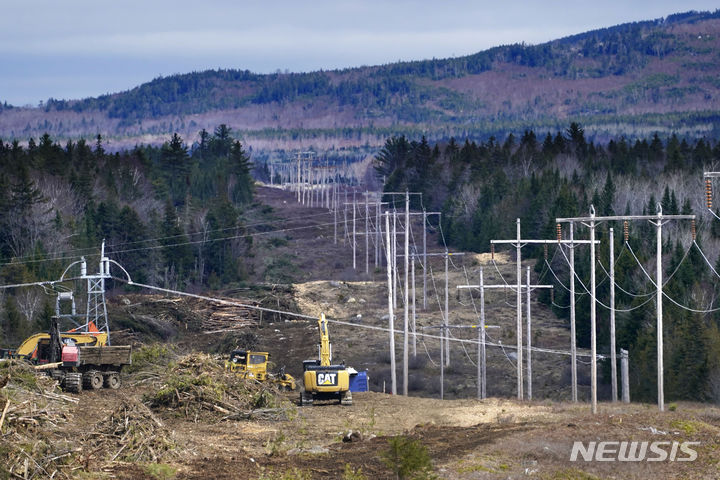 [메인(미국)=AP/뉴시스] 전 세계적으로 구축된 전력망이 친환경 에너지의 보급 속도를 따라가지 못해 기후변화를 가속할 것이라는 분석이 나왔다고 미국 AP통신이 16일(현지시간) 전했다. 사진은 미국 메인주 빙엄 인근에서 새로운 전봇대를 세우는 작업을 하고 있는 모습. 2023.10.17.