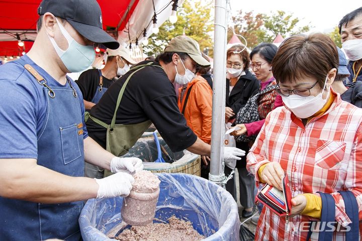 [서울=뉴시스] 지난해 마포나루 새우젓축제에서 구민이 새우젓을 구매하고 있다.(제공=마포구)