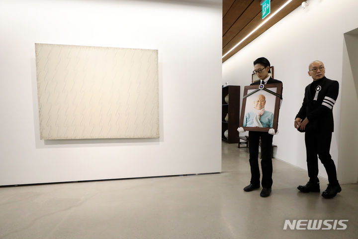 [서울=뉴시스] 박진희 기자 = 추상미술 '단색화'의 거장 박서보 화백의 발인식이 열린 17일 아들 박승호와 손자 박지환이 영정을 들고 서울 서대문구 연희동 자택(작업실)을 돌아보고 있다. 2023.10.17. pak7130@newsis.com