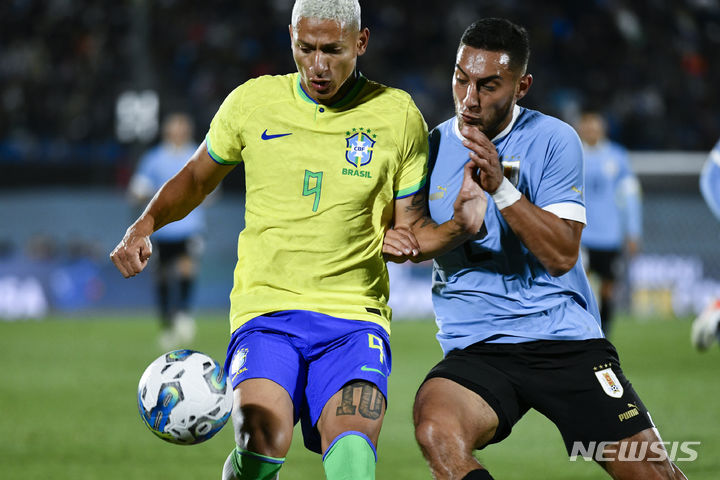 [몬테비데오(우르과이=AP/뉴시스] 지난해 10월17일 우르과이 몬테네비오에 위치한 에스타디오 센터나리오 경기장에서 열린 '2026 국제축구연맹(FIFA) 월드컵' 남미지역예선 브라질과 우르과이의 경기에서 브라질의 히샬리르송이 우르과이의 세바스티안 카세레스와 공을 두고 경합하고 있다. 2023.10.17.