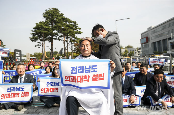 [서울=뉴시스] 정병혁 기자 = 더불어민주당 김원이 의원이 18일 서울 용산구 전쟁기념관 앞에서 열린 윤석열정권 전라남도 의과대학 유치 촉구 집회에서 삭발을 하고 있다. 2023.10.18. jhope@newsis.com