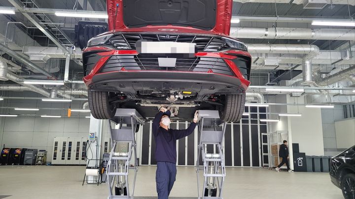 [양산=뉴시스]&nbsp; 강주희 기자=현대자동차는 19일 경남 양산시 하북면 현대 인증중고차 양산센터에서 미디어데이를 열고 인증증고차 사업 공식 출범을 알렸다. 샹품화 B동에서 한 작업자가 리프트로 올린 차량의 내부를 살펴보고 있다. 2023.10.19 zooey@newsis.com *재판매 및 DB 금지