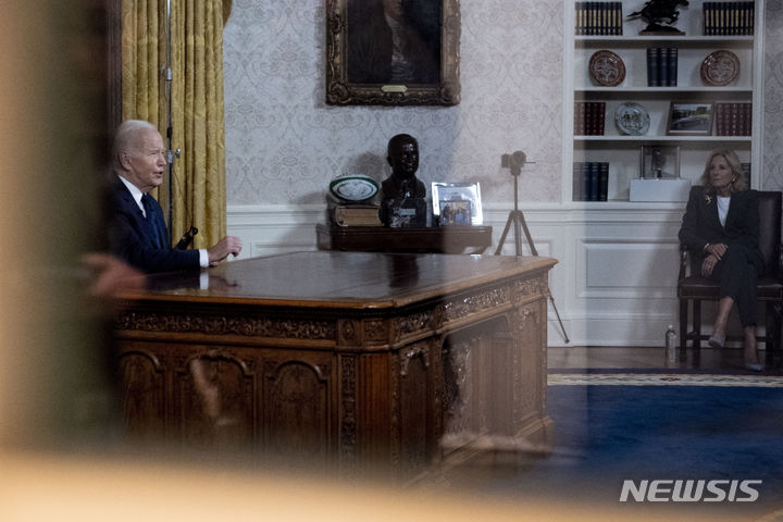 [워싱턴=AP/뉴시스] 조 바이든 미국 대통령이 19일(현지시간) 백악관 집무실에서 이스라엘과 우크라이나 전쟁에 관해 대국민 연설을 하는 가운데 질 바이든 여사가 이를 지켜보고 있다. 바이든 대통령은 "핵심 동맹인 이스라엘과 우크라이나 지원을 포함한 긴급 안보 예산을 의회에 요청할 것"이라며 "이스라엘과 우크라이나가 승리하는 것이 미국 안보에 중요하다"라고 말했다. 2023.10.20.