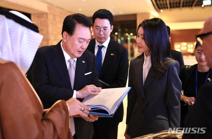 [리야드=뉴시스] 전신 기자 = 사우디아라비아를 국빈 방문한 윤석열 대통령과 부인 김건희 여사가 21일(현지시간) 리야드 인근 디리야 유적지를 방문해 디리야 화보집을 살펴보고 있다. (공동취재) 2023.10.22. photo1006@newsis.com