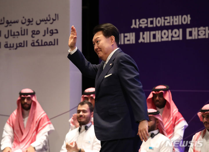 [리야드=뉴시스] 전신 기자 = 사우디아라비아를 국빈 방문 중인 윤석열 대통령이 23일(현지시간) 리야드 킹 사우드 대학교에서 열린 사우디아라비아 미래 세대와의 대화에서 '청년, 미래를 이끄는 혁신의 주인공'을 주제로 강연하기 위해 연단으로 나서며 손을 들어 인사하고 있다. 2023.10.23. photo1006@newsis.com