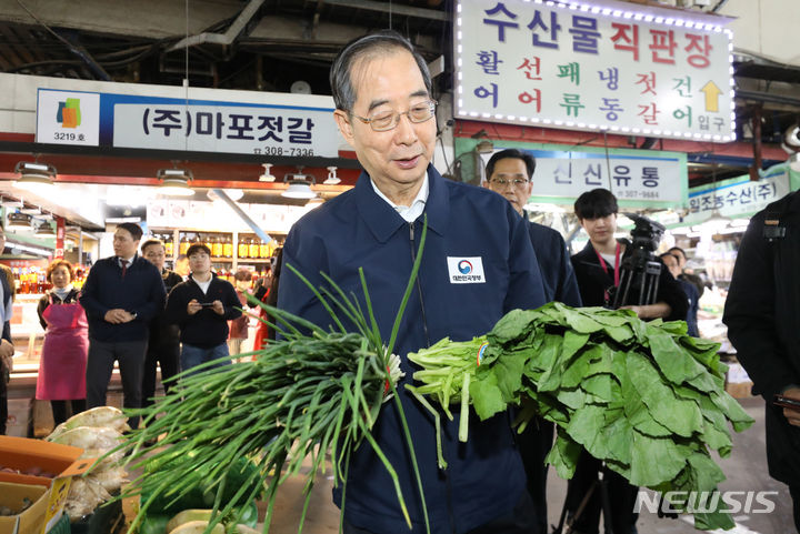 [서울=뉴시스] 황준선 기자 = 한덕수 국무총리가 24일 오후 서울 마포구 마포농수산물시장을 방문해 쪽파와 갓을 살펴보고 있다. 2023.10.24. hwang@newsis.com