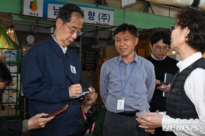 [서울=뉴시스] 황준선 기자 = 한덕수 국무총리가 24일 서울 마포구 마포농수산물시장을 방문해 마늘 등 김장재료를 살펴본 뒤 상인의 건의사항을 메모하고 있다. 한 총리는 이날 농수산물 물가를 점검하고 상인들을 격려했다. (공동취재)2023.10.24. photo@newsis.com