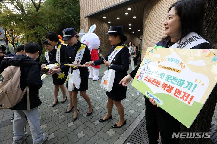 [서울=뉴시스] 김명년 기자 = 25일 오전 서울 양천구 양명초등학교 앞에서 열린 '2023 스쿨존 교통사고 제로 캠페인'에서 참가자들이 등교하는 학생에게 교통안전 배지를 나눠주고 있다. 2023.10.25. kmn@newsis.com