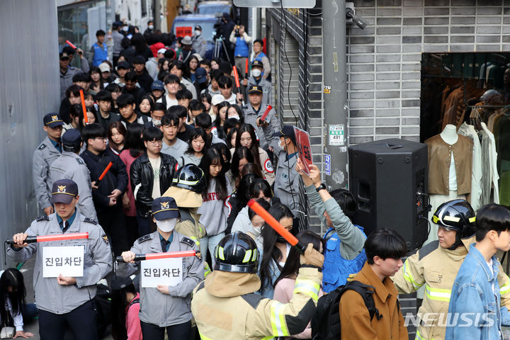 [서울=뉴시스] 김선웅 기자 = 지난 25일 서울 광진구 건대입구역 인근 건대맛의거리에서 다중운집 상황 발생을 가정한 인파감지 시스템 활용 인파밀집 예방 합동 훈련이 진행되고 있다. 2023.10.25. mangusta@newsis.com