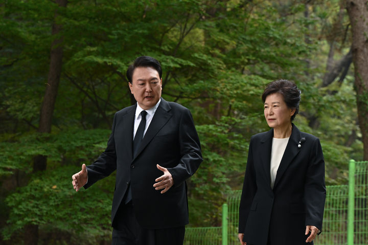 [서울=뉴시스] 윤석열 대통령이 26일 국립서울현충원에서 열린 박정희 전 대통령 44주기 추도식에서 박정희 전 대통령 묘역에 참배한 뒤 박근혜 전 대통령과 대화를 나누며 이동하고 있다. (대통령실 제공) 2023.10.26. photo@newsis.com *재판매 및 DB 금지