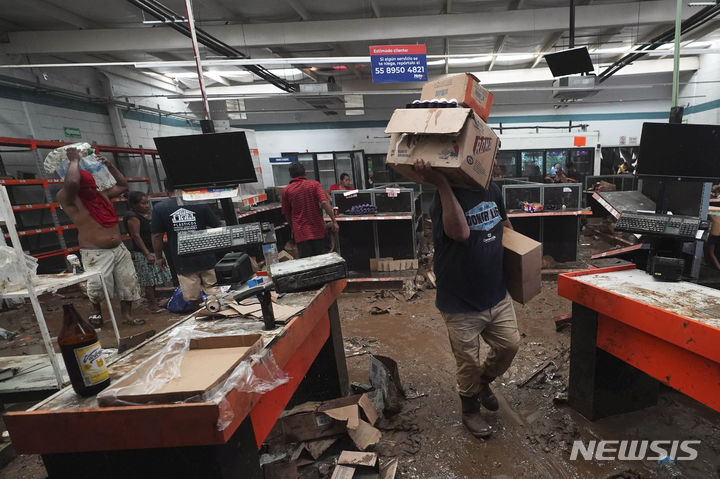 [아카풀코=AP/뉴시스] 폭풍 오티스로 피해를 입은 지역 상점에서 물건을 훔쳐가고 있는 주민들의 모습. 2023.10.27.