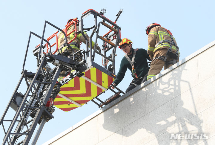 [대전=뉴시스] 강종민 기자 = 27일 대전시 유성구 기초과학연구원에서 지진 발생을 가정해 열린 2023 국가단위 긴급구조 종합훈련에서 구조대원들이 건물옥상에 고립된 인원을 구조하고 있다. 2023.10.27. ppkjm@newsis.com