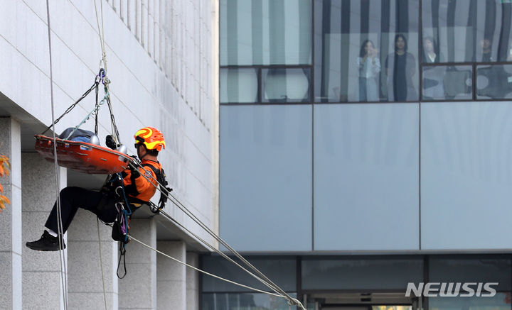 [대전=뉴시스] 강종민 기자 = 27일 대전시 유성구 기초과학연구원에서 지진 발생을 가정해 열린 2023 국가단위 긴급구조 종합훈련에서 구조대원의 인명구조 모습을 시민들이 보고 있다. 2023.10.27. ppkjm@newsis.com