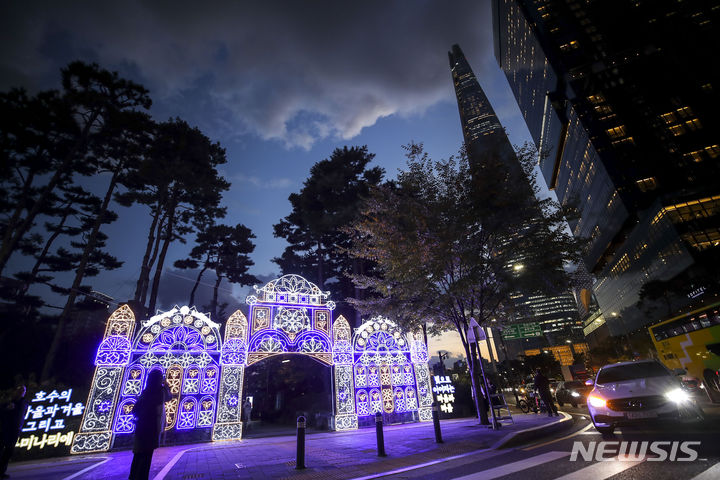 [서울=뉴시스] 정병혁 기자 = 27일 서울 송파구 석촌호수에서 열린 '호수의 가을과 겨울 그리고 루미나리에'를 찾은 시민들이 형형색색으로 꾸며진 빛 터널을 지나며 즐거운 시간을 보내고 있다. 2023.10.27. jhope@newsis.com