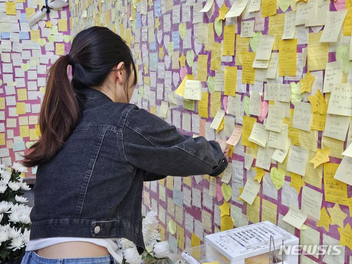 [서울=뉴시스] 박광온 기자 = 28일 오후 5시께 서울 용산구 이태원에 차려진 '기억과 안전의 길' 벽면에 한 시민이 애도 글을 적은 포스트잇을 붙이고 있다. 2023.10.28. lighton@newsis.com