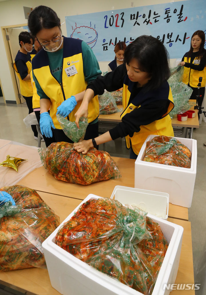 [서울=뉴시스] 최진석 기자 = 28일 서울 강서구 통일부 남북통합문화센터에서 열린 '2023 맛있는 통일, 음식 나눔 자원봉사' 행사에서 MZ세대 남북주민 자원봉사자들이 탈북청소년들이 담근 김장김치를 포장하고 있다. 2023.10.28. myjs@newsis.com