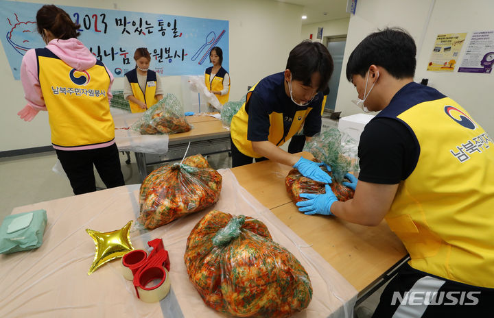 [서울=뉴시스] 최진석 기자 = 28일 서울 강서구 통일부 남북통합문화센터에서 열린 '2023 맛있는 통일, 음식 나눔 자원봉사' 행사에서 MZ세대 남북주민 자원봉사자들이 탈북청소년들이 담근 김장김치를 포장하고 있다. 2023.10.28. myjs@newsis.com