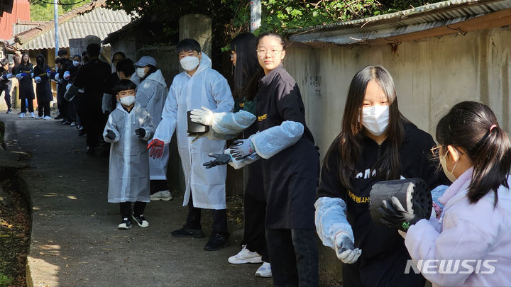 [광주=뉴시스] 맹대환 기자 = 광주온정나눔봉사단에 참여한 학생과 교사가 28일 오전 광주 광산구 신가동 한 독거어르신 주택에 연탄을 배달하고 있다. 2023.10.28. mdhnews@newsis.com