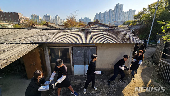 [광주=뉴시스] 맹대환 기자 = 광주온정나눔봉사단에 참여한 학생과 교사가 28일 오전 광주 광산구 신가동 한 독거어르신 주택에 연탄을 배달하고 있다. 2023.10.28. mdhnews@newsis.com