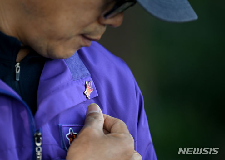 [광주=뉴시스] 이영주 기자 = 10·29 이태원 참사를 하루 앞둔 28일 오전 참사 희생자 고(故) 김연희씨의 아버지 김상민(55)씨의 외투에  달린 참사 희생자들을 추모하는 뜻을 담고 있는 배지가 햇빛을 받아 빛나고 있다. 2023.10.28. leeyj2578@newsis.com