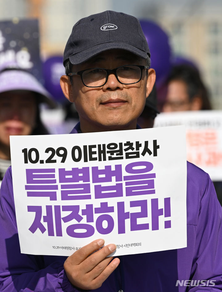 [광주=뉴시스] 이영주 기자 = 10·29 이태원 참사를 하루 앞둔 28일 오전 참사 희생자 고(故) 김연희씨의 아버지 김상민씨가 이태원 참사 특별법 제정 촉구 걷기 행사에 참여해 손팻말을 들고 있다. 2023.10.28. leeyj2578@newsis.com