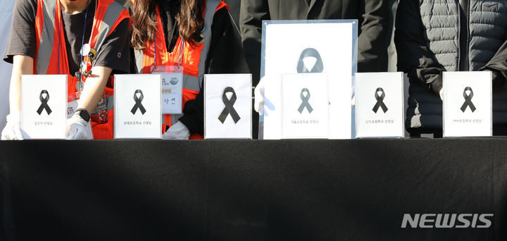 [서울=뉴시스] 최진석 기자 = 28일 서울 여의도 국회 앞에서 열린 '50만교원 총궐기 아동복지법 개정 촉구 집회'에서 교사들이 극단적 선택을 한 동료교사들을 추모하고 있다. 주최 측은 "작은 액자는 지난 7월18일 서울 서이초등학교 교사 사망 사건 이후 스스로 목숨을 끊은 선생님 6분을, 큰 액자는 지금까지 극단적 선택으로 내몰린 모든 교사를 의미한다"고 했다. 2023.10.28. myjs@newsis.com